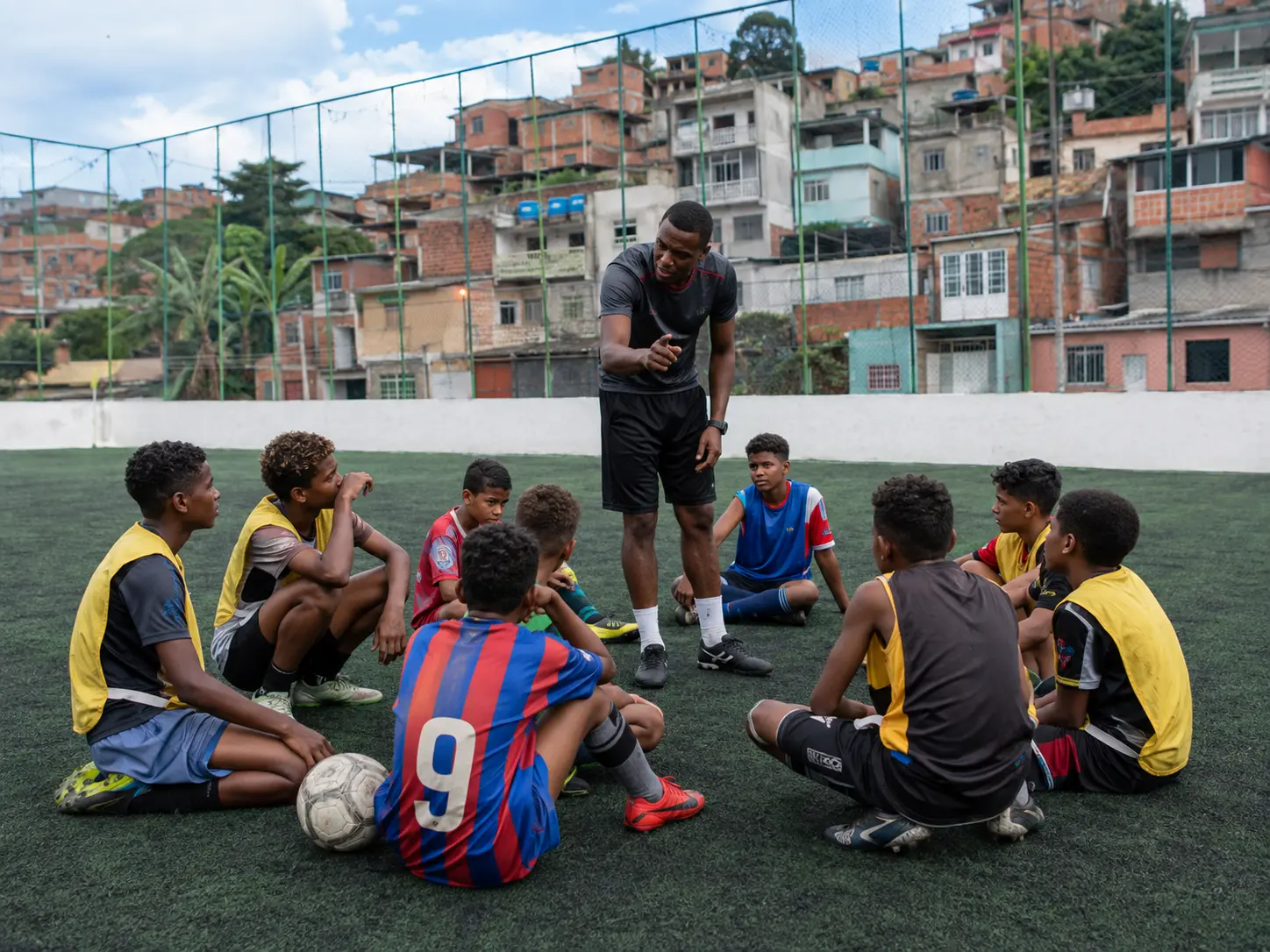 Educador orienta jovens durante uma atividade esportiva comunitária.